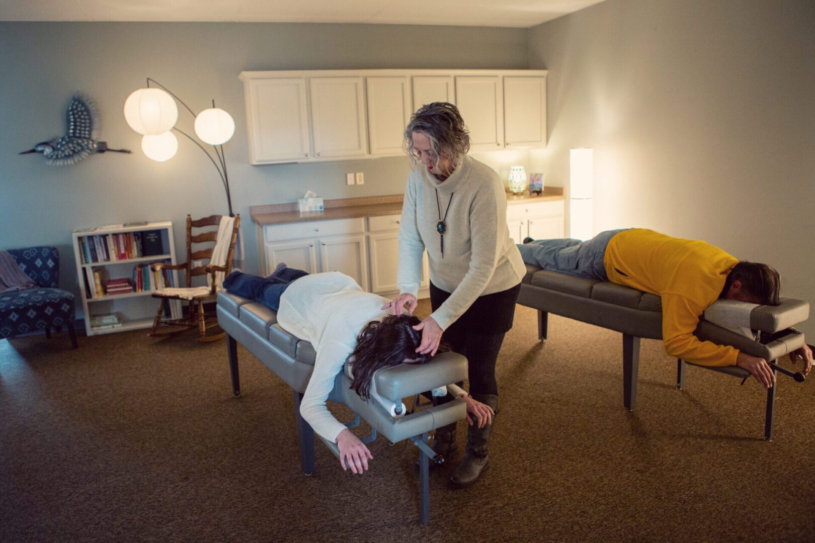 A woman is getting her back examined by an osteopath.