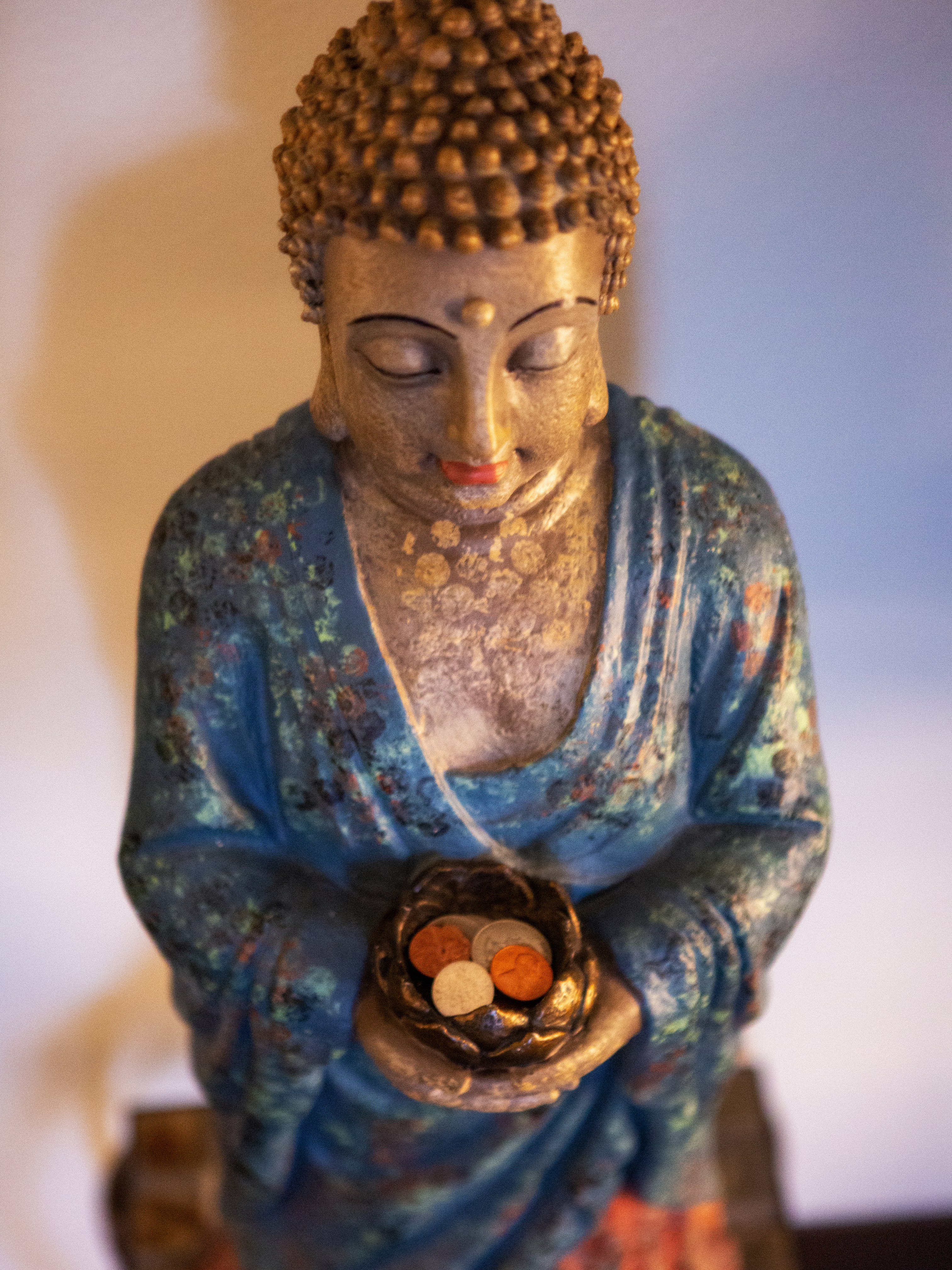 A statue of buddha holding a bird nest.